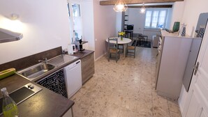 Uma cozinha moderna com lava-louças, pia e área de refeições com mesa e cadeiras.