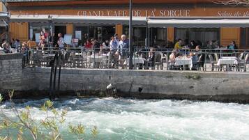 Un café situé au bord de la rivière, avec une terrasse offrant une vue sur le cours d’eau.