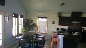A kitchen with a dining area, a large window, and a ceiling fan. - beachouse 1/2block to convention center/ restaurants/bars (Galveston)