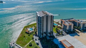 A high-rise hotel with a pool and beach access, overlooking a coastal area with clear blue waters. - Amazing Gulf Views w/Private Beach, shelling & fishing on property! (Marco Island)