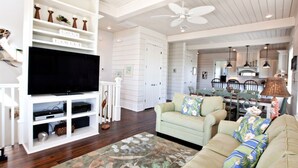 A spacious living room with a flat-screen TV, a beige sofa, and a floral rug. - *PRIVATE BEACH*    *PRIVATE POOL*    *ELEVATOR*    *6 BEACH BIKES* (inlet beach)