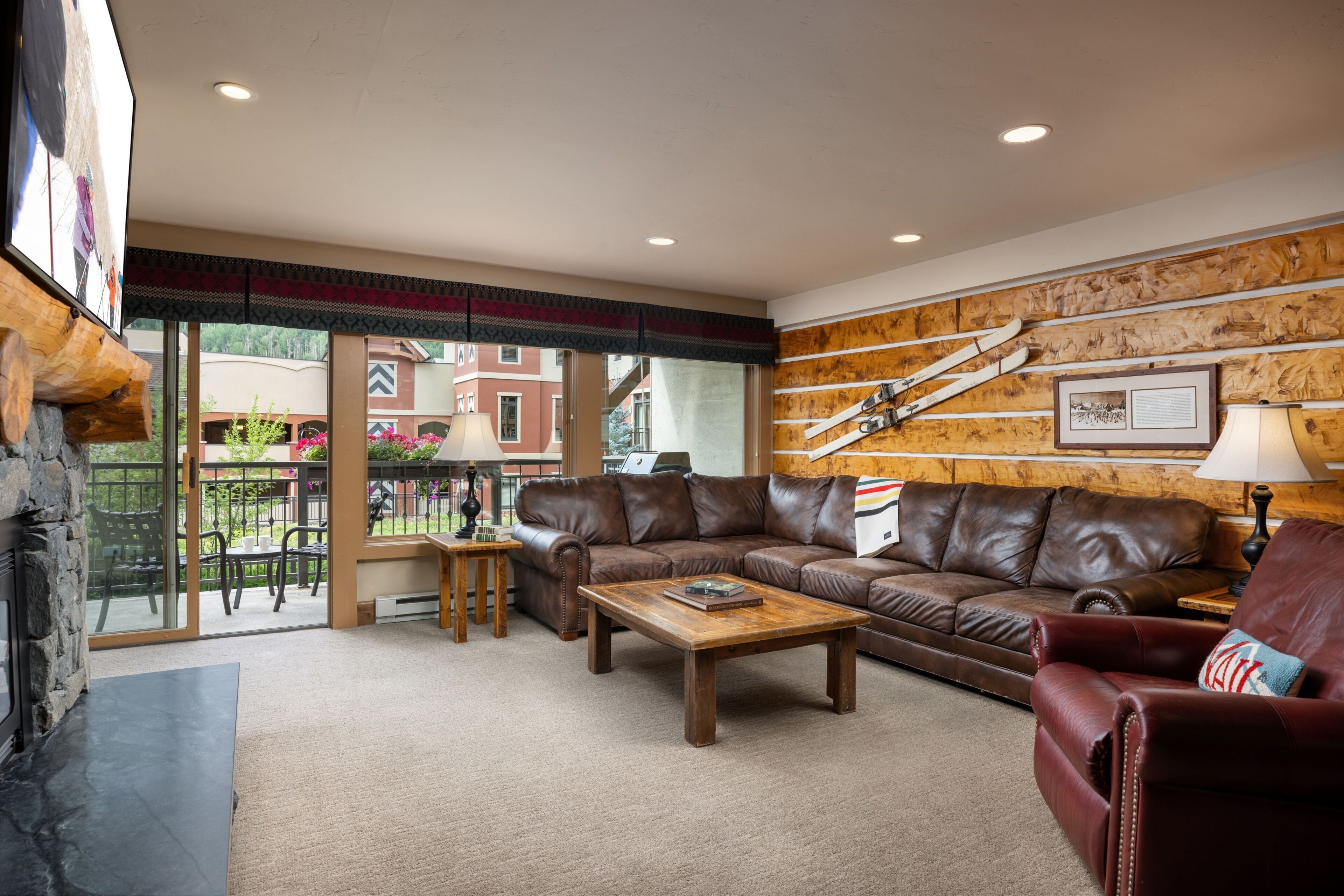 A cozy living room with a leather sofa, a wooden coffee table, and a fireplace.