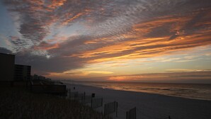 A beach with a wooden fence and a building in the background. - Stunning Gulf View Unit.......Last Minute Discounts Available! (Destin)