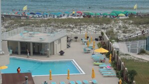 A pool area with lounge chairs and umbrellas, a pool, and a beach in the background. - Stunning Gulf View Unit.......Last Minute Discounts Available! (Destin)
