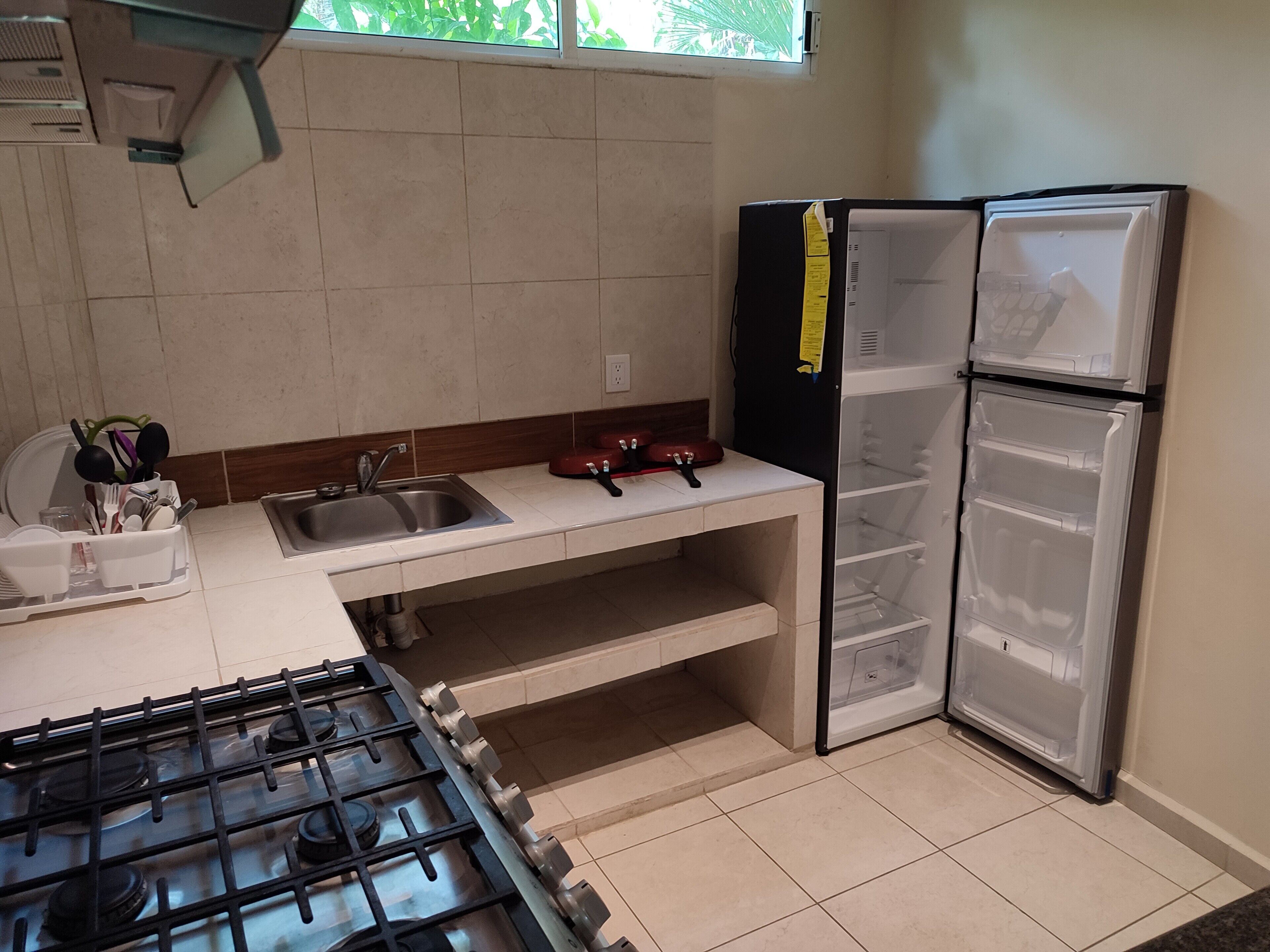 A compact kitchen with a gas stove, a sink, and a refrigerator.
