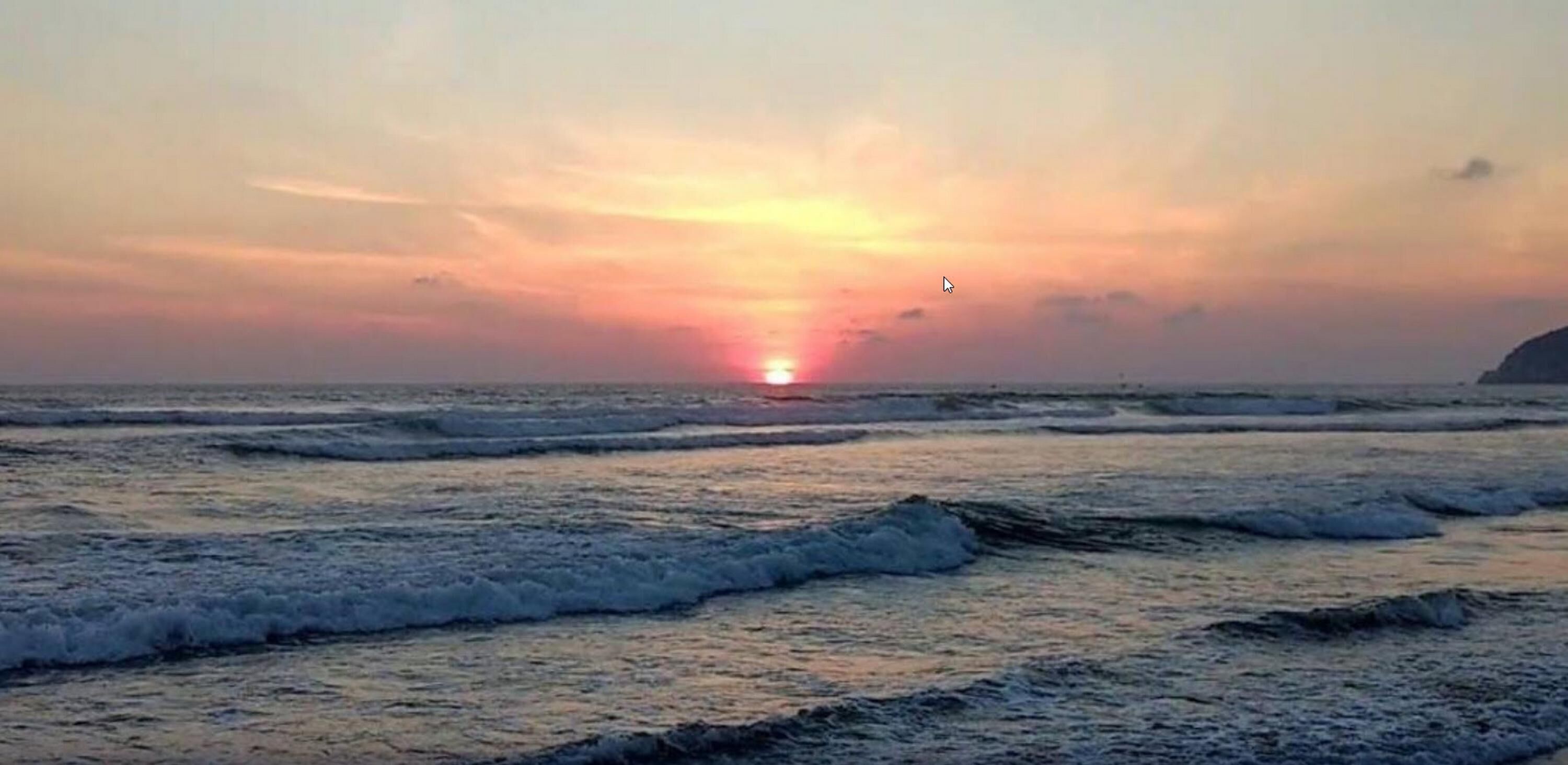 Una puesta de sol sobre el océano con olas.