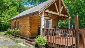 A wooden cabin with a porch, a door, and a window.