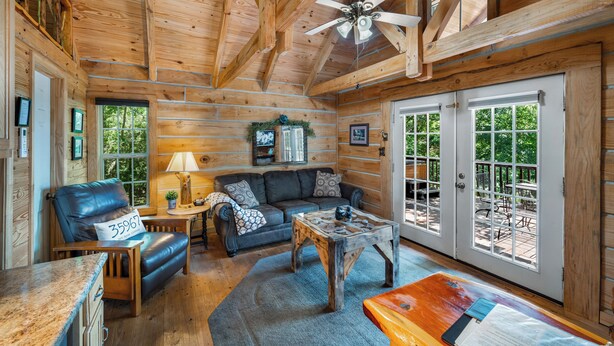 A log cabin interior with a sofa, armchair, and coffee table.