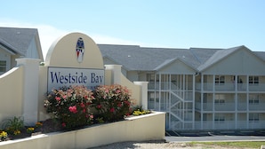 A hotel entrance with a sign reading "Westside Bay" and a building with multiple balconies.
