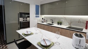 A modern kitchen with a marble countertop, a built-in oven, and a toaster.