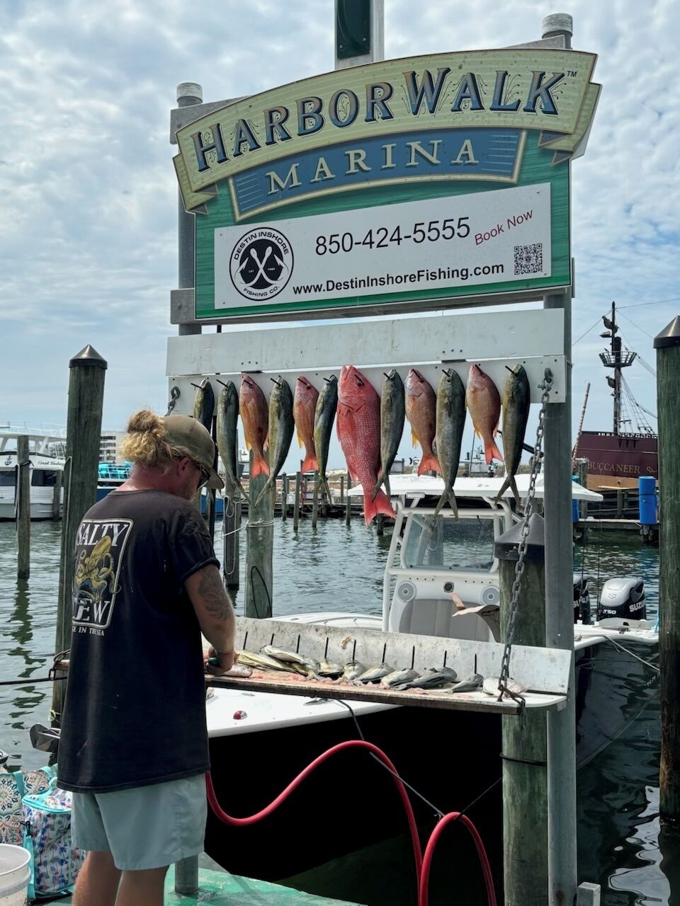 A fishing charter sign with contact information and a website URL.