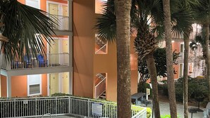 A multi-story building with balconies, a swimming pool, and palm trees. - Private Beach & Free Beach Service; Walkable Scenic 98 to Dining; Pool & Hot Tub (Miramar Beach)