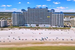 A large hotel with a modern design, featuring multiple balconies and a pool area. - Beachfront 2 BR + Bunks — Family Friendly — No Added Fees — 100+ ★★★★★ Reviews  (Gulf Shores)