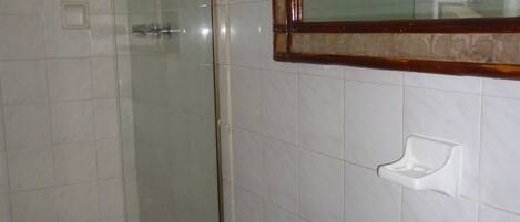 Ein Badezimmer mit Toilette, Waschbecken und einer Duschkabine aus Glas.