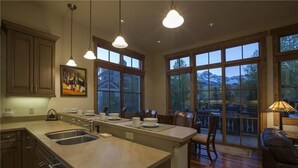 A spacious kitchen with a large island, multiple windows, and a dining area with a view of the mountains. - Belvedere Park 1 (Telluride)