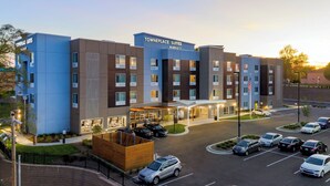 Ein mehrstöckiges Hotel mit modernem Design, erkennbar am gut sichtbaren Schild für 'Towneplace Suites Marriott'.