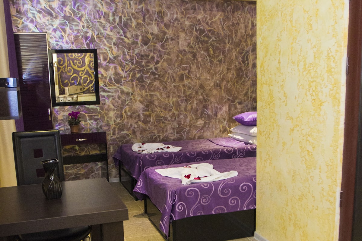 Une chambre d’hôtel avec deux lits, un bureau et une chaise.