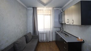 A compact kitchen with a built-in oven, a sink, and a cabinet above the counter. - Planet Yerevan Hotel (Yerevan)