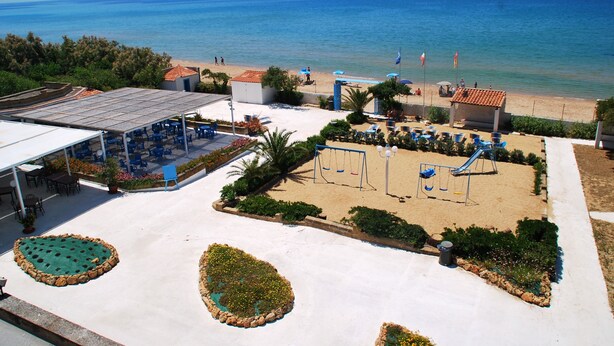 A beachside resort with a pool area, outdoor seating, and a playground. - Residence le 4 stagioni (Menfi)