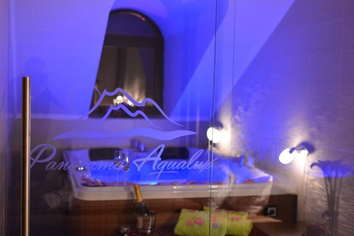 A bathroom with a bathtub, a mirror, and a towel rack.