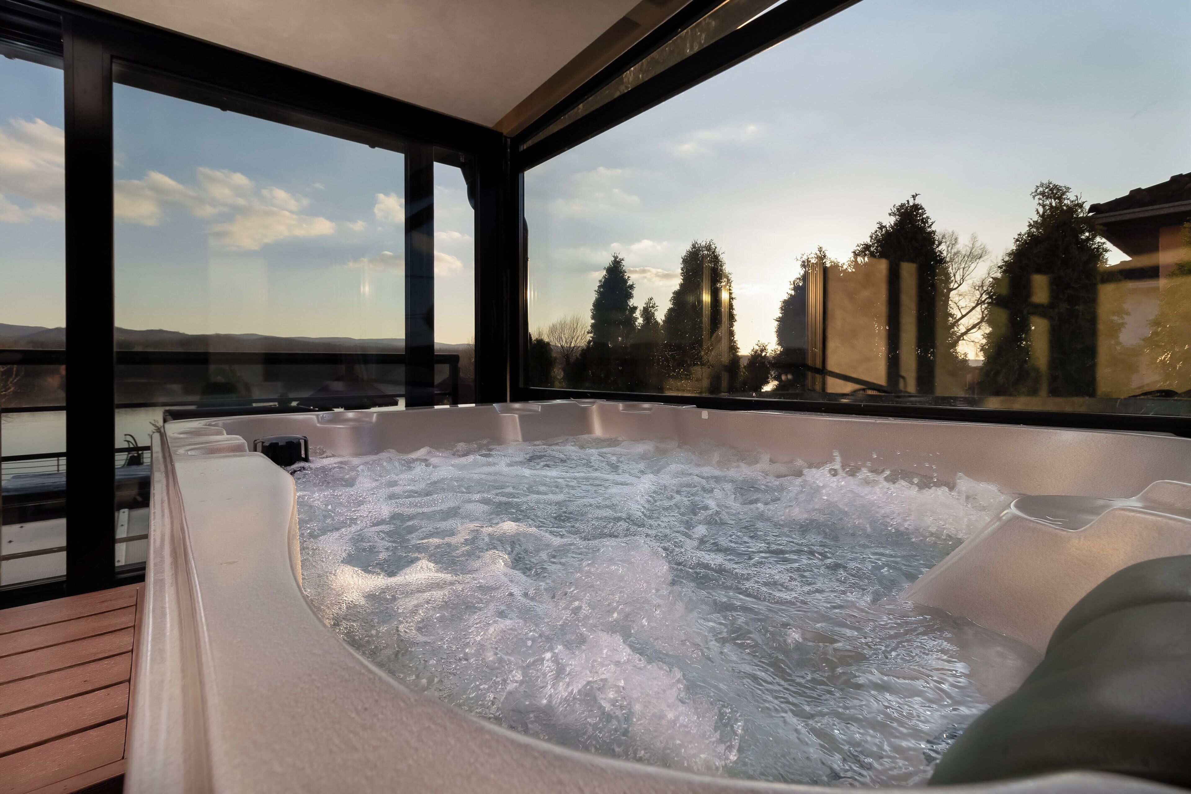 Un jacuzzi con vista a un lago y árboles.