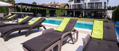 A poolside area with lounge chairs and a pool.