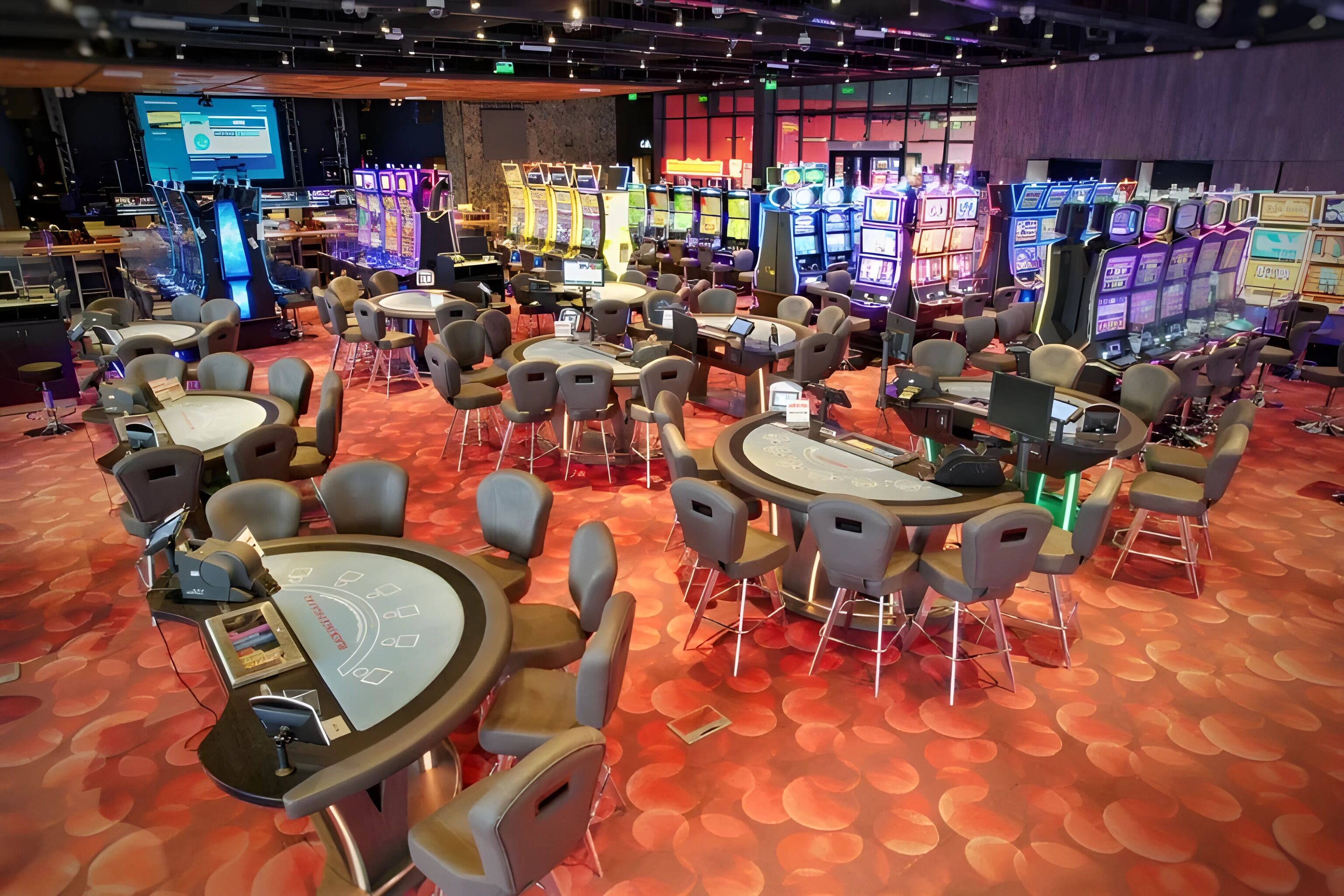 A casino floor with gaming tables and slot machines.