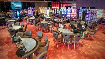 A casino floor with gaming tables and slot machines.