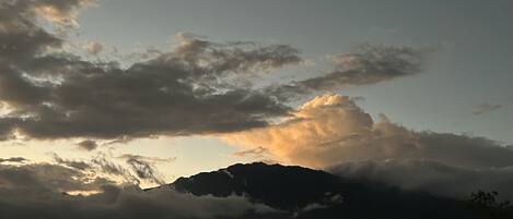 Paesaggio montano con nuvole e un tramonto.