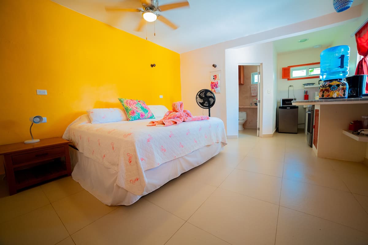 A bedroom with a bed, bedside table, and a ceiling fan.