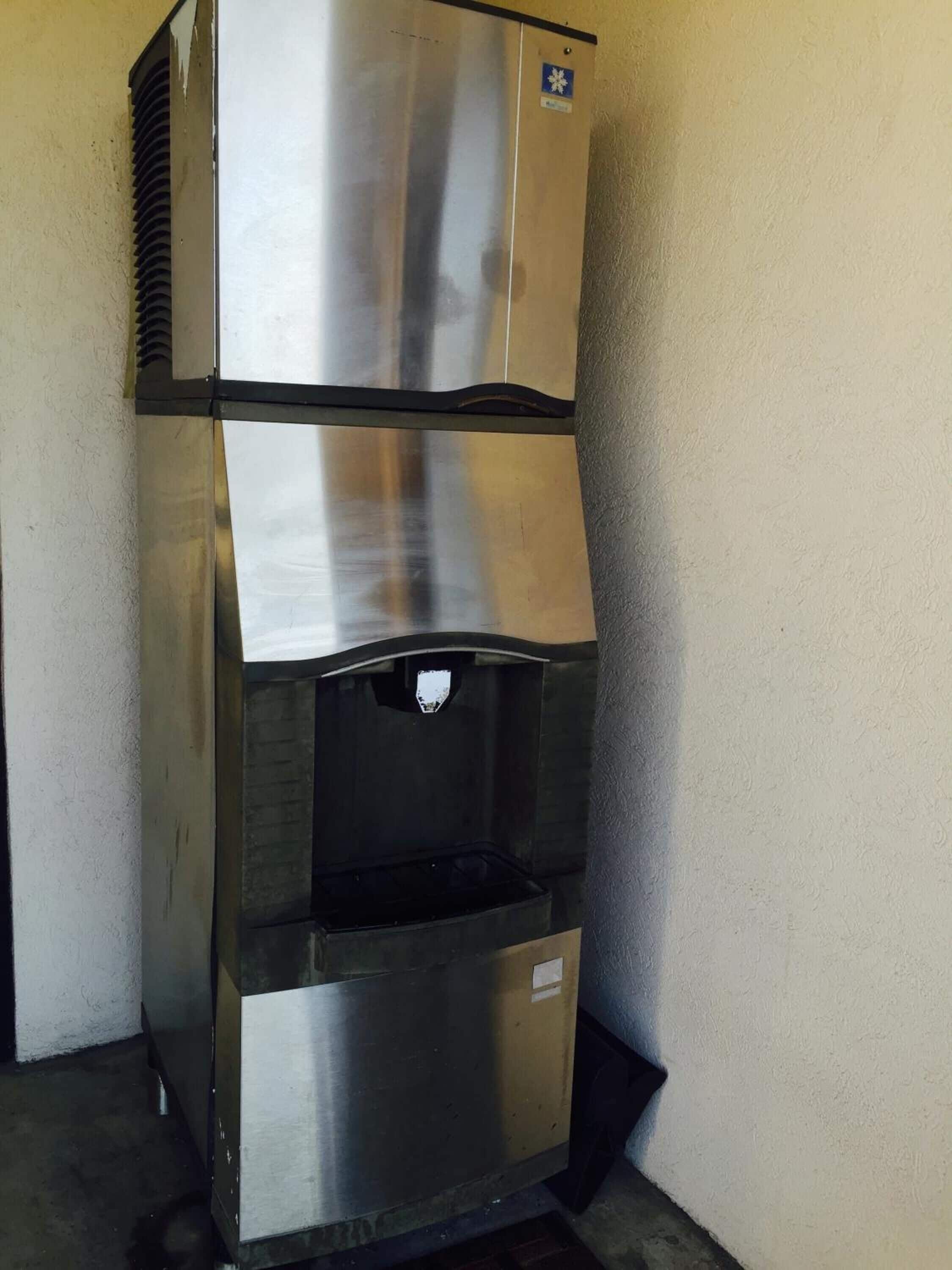 A stainless steel commercial refrigerator with a water dispenser and a freezer compartment.