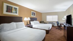 A hotel room with two beds, a desk, a chair, a TV, and artwork on the walls.
