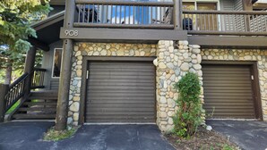 A two-story house with a stone facade, a balcony, and a garage. - Snowcreek Resort Vacation Rental 908 (Mammoth Lakes)