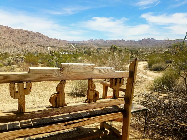 A wooden bench with a table in a desert landscape.