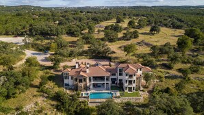 A large, modern house with a swimming pool, surrounded by a lush green landscape. - High-end Home on 33 Acres to Roam, Short Drive to Downtown. (Austin)