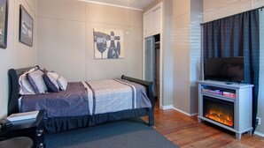 Un dormitorio con cama, televisión y chimenea.