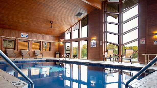 A swimming pool with a wooden interior, clear glass walls, and a sign indicating no diving.