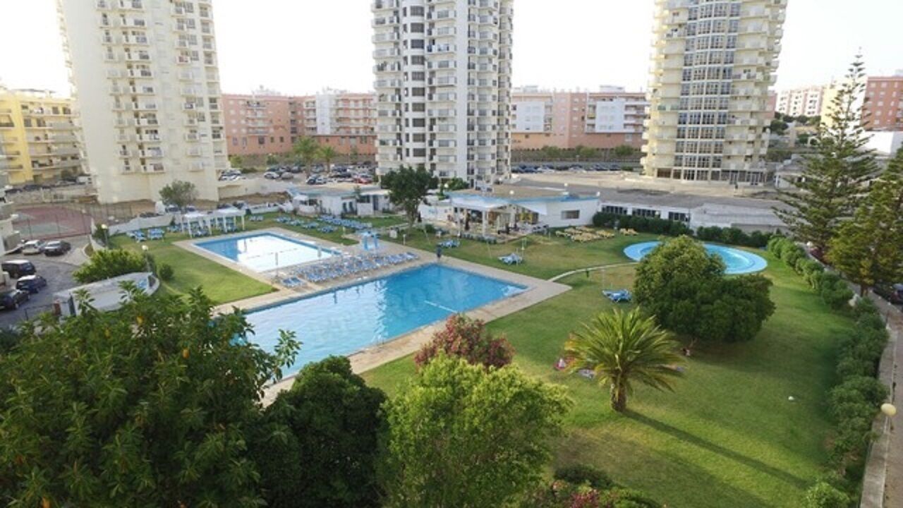 Un quartier résidentiel comprenant plusieurs immeubles de grande hauteur, une piscine et de nombreux espaces verts.