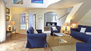 A spacious living area with a high ceiling, a large window, and a view of the sea. - Luxury Provencal villa with heated pool and gym in St Paul (Saint-Paul-De-Vence)