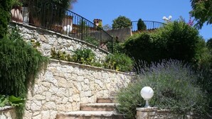 A stone staircase with metal railings, surrounded by lush greenery and lavender plants. - Luxury Provencal villa with heated pool and gym in St Paul (Saint-Paul-De-Vence)
