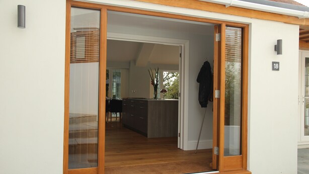 A modern house with a sliding glass door leading to a kitchen with wooden flooring and a dining area visible through the door. - Open Plan Holiday Cottage Within Walking Distance Of Westbourne And Beach (Poole)