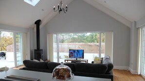 A modern living room with a fireplace, a sofa, a coffee table, and a television. - Open Plan Holiday Cottage Within Walking Distance Of Westbourne And Beach (Poole)