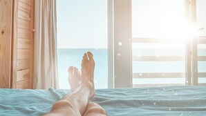 A bed with a view of the sea through a window. - PG Beach House II - seaside serenity blends with refined comfort (Sintra)
