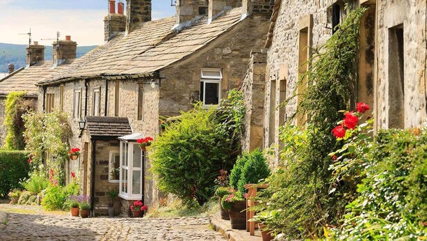 A stone-built cottage with a traditional design, a cobblestone street, and lush greenery. - Boutique style centrally located terrace, award winning Skipton Yorkshire Dales (Skipton)