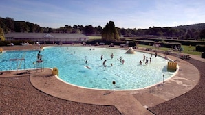 A large outdoor swimming pool with multiple lanes, surrounded by a paved deck and a grassy area. - Boutique style centrally located terrace, award winning Skipton Yorkshire Dales (Skipton)