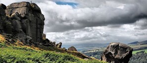A rugged landscape with prominent rock formations and a distant view of rolling hills under a cloudy sky. - Boutique style centrally located terrace, award winning Skipton Yorkshire Dales (Skipton)