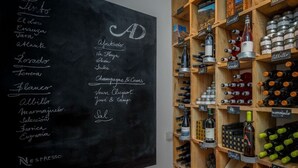 Eine Tafel mit einer Weinkarte und ein Weinkühler mit Flaschen.