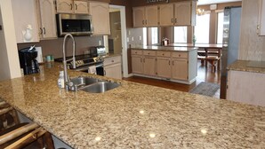 Una cocina con encimeras de granito, electrodomésticos de acero inoxidable y armarios de madera.