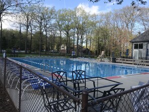 Relax by the pool surrounded by lush trees and a serene outdoor setting.