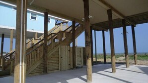 A wooden staircase leading to a covered outdoor area with a view of the beach. - BEACH FRONT with panoramic views of the Gulf Coast. (Bolivar Peninsula)